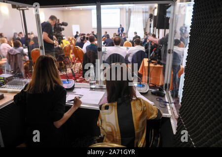 Two women translators sit in a translating cabin during an international conference Stock Photo