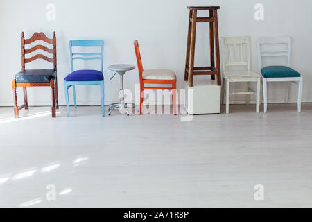 different multicolored chairs in the interior of the white room Stock Photo