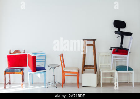 different multicolored chairs in the interior of the white room Stock Photo