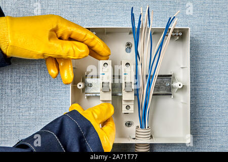 The electric installation work of devices of engineering networks and systems.The electrician carries out wiring services and rewiring consumer unit o Stock Photo