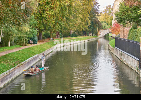 Students punting on the river Cam past Queens' college and King's college, university of Cambridge, England, on a sunny autumn day.