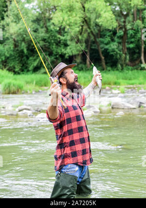 real happiness. mature man fly fishing. man catching fish. summer