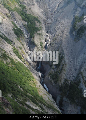 The Sandy River emerging from under lower rock covered part of the lower Reid Glacier and plunging down the side of Mt. Hood. Viewed from Yocum Ridge. Stock Photo