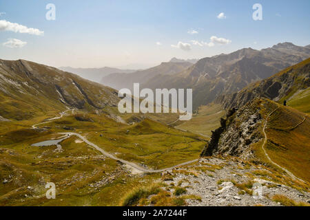 Elevated view of Colle dell'Agnello mountain pass with the winding road and the Lake of Pic d'Asti in late summer, Chianale, Cuneo, Piedmont, Italy