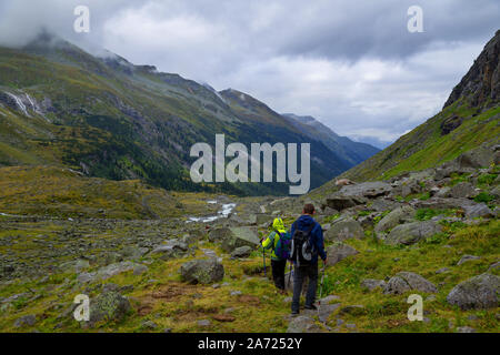 Young couple is hiking on a rainy day in Austrian mountains near Großvenediger Stock Photo