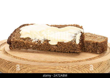 Group of two slices with butter of dark bread on bamboo plate isolated on white background Stock Photo