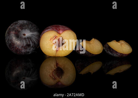 Group of one whole one half two slices of fresh red plum isolated on black glass Stock Photo
