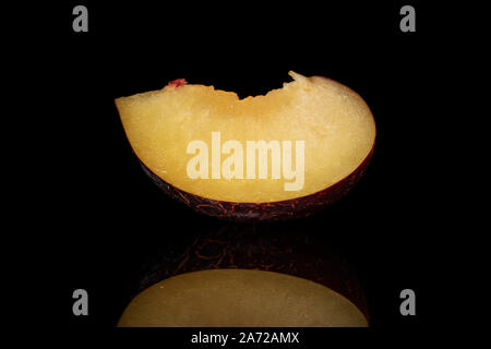 One slice of fresh red plum isolated on black glass Stock Photo