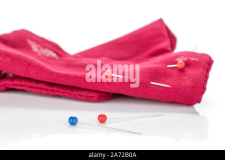 One whole haberdashery item red cloth with needles isolated on white background Stock Photo