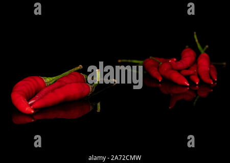 Lot of whole hot red chili isolated on black glass Stock Photo