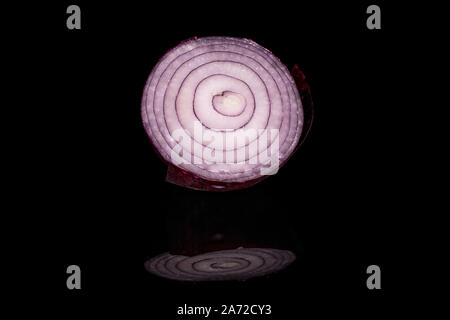 One half of tasty onion red isolated on black glass Stock Photo