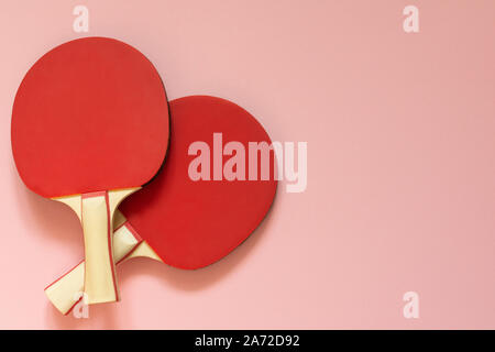 Red tennis ping pong rackets isolated on a pink background, sport equipment for table tennis Stock Photo