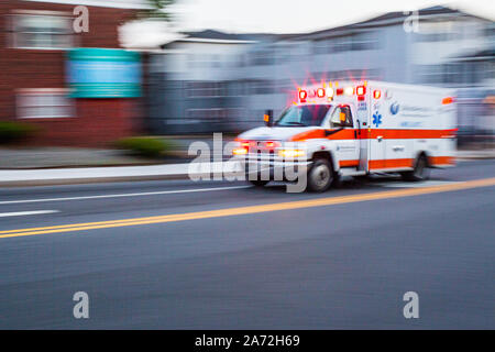 An ambulance speeding down Highland Street in Worcester, MA Stock Photo