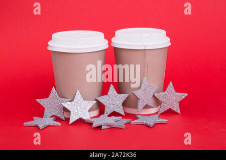 Paper cups for coffee on a red background with New Year stars. Stock Photo
