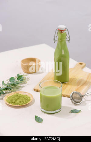 Matcha green tea latte in bottle and cup glass on white background Stock Photo