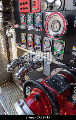 Valves and pump panel on the side  of a red fire truck Stock Photo