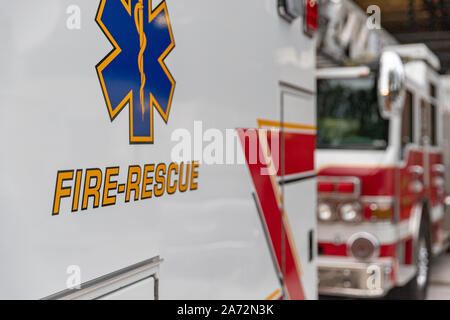 Side view of an ambulance rescue vehicle parking in front of a fire engine Stock Photo