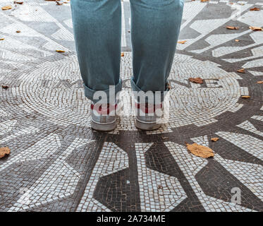 NEW YORK CITY, USA - 2017 SEPTEMBER 7, Woman legs over The caption "Imagine" on the "The Beatles" memorial mosaic, in Strawberry Fields (Central Park) Stock Photo