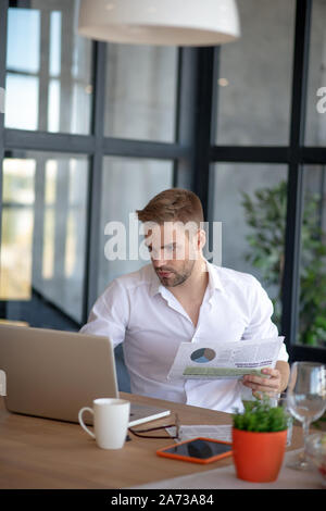 Businessman reading news and checking e-mail on laptop Stock Photo