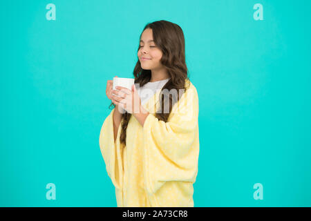 Relaxation before sleep. Drinking milk just before heading to bed. Bedtime Beverages. Evening routine. Health Benefits of Drinking Milk Before Bed. Little child hold mug. Girl in pajamas drinking tea. Stock Photo