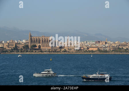 Boats Sailing Past the Gothic Medieval Roman Catholic Cathedral of Santa Maria of Palma in Mallorca, Spain, EU. Stock Photo