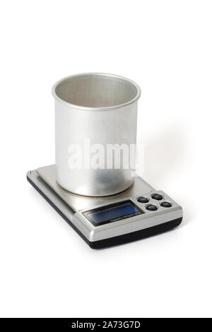 Aluminum beaker staying on digital scales. White background Stock Photo