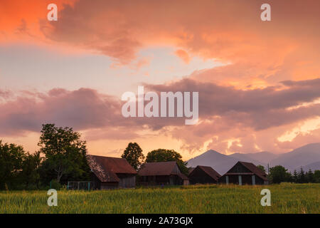 Clearing storm over a rural landscape with a traditional barn in Turiec region, central Slovakia. Stock Photo