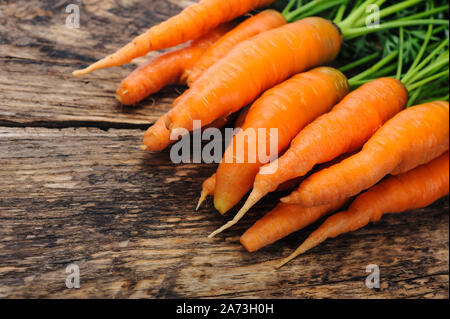 Bunch of fresh organic carrots on a wooden rustic table Stock Photo