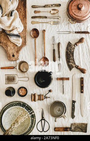 Various kitchen utensils and tablewear over linen tablecloth, vertical composition Stock Photo