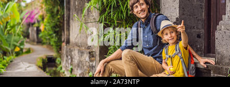 Father and son tourists in Bali walks along the narrow cozy streets of Ubud. Bali is a popular tourist destination. Travel to Bali concept. Traveling Stock Photo