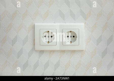 Electrical jack white plastic socket on a white wall Stock Photo