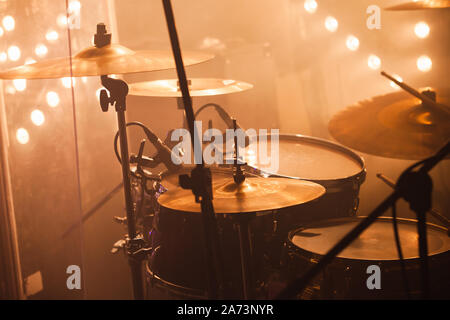 Rock band drum set with cymbals stands on a stage with strobe lights Stock Photo