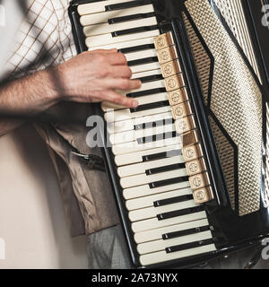 Accordionist plays vintage accordion. Close-up square photo with selective focus Stock Photo