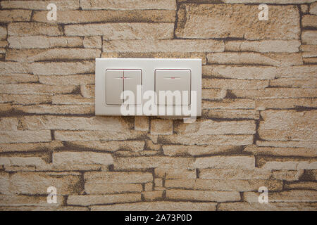 two white lighting switchs on concrete wall, on and off Stock Photo