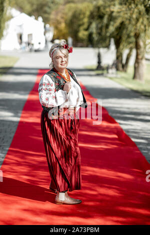 Portrait of a woman dressed in Ukrainian national dress as a well-known actress on the red carpet during awards ceremon Stock Photo