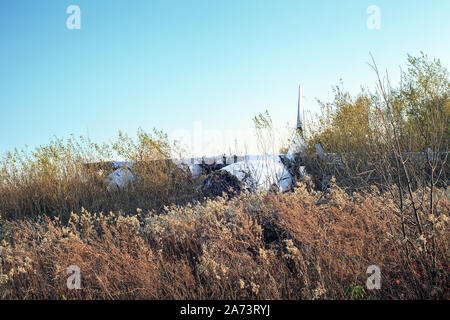 Broken plane after crash in field. Crashed plane after accident on ground at sunset Stock Photo