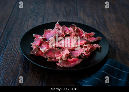 Turkish Bacon Pastirma / Pastrami Slices in Black Plate. Ready to Eat and Serve from Kastamonu and Kayseri. Traditioanal Organic Food. Stock Photo