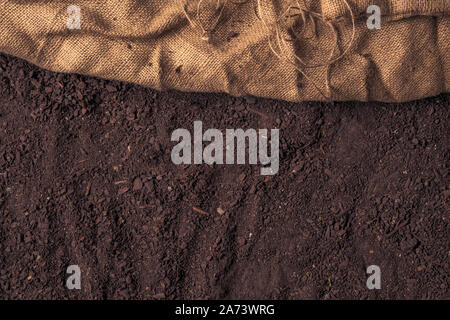 Botany humus compost soil mix top view with hessian burlap sack, abstract natural texture Stock Photo