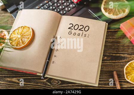 Notepad with open pages and pen on wooden background. Planning goals for the new year on Christmas eve. Space for text. The view from the top Stock Photo