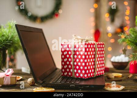 Gift red box with white polka dots on the laptop. Purchase discounts for Christmas in online stores on new year's eve Stock Photo