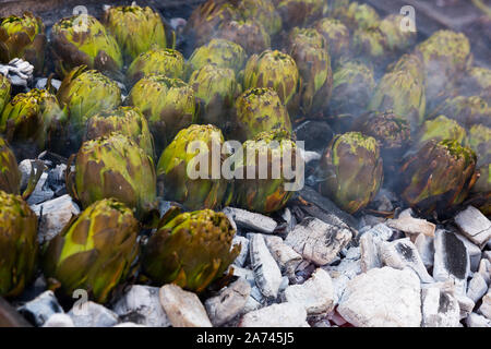 Closeup of artichokes being grilled on ember. Healthy outdoor eating Stock Photo