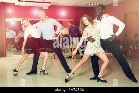 Young smiling people practicing passionate samba in dance class Stock Photo