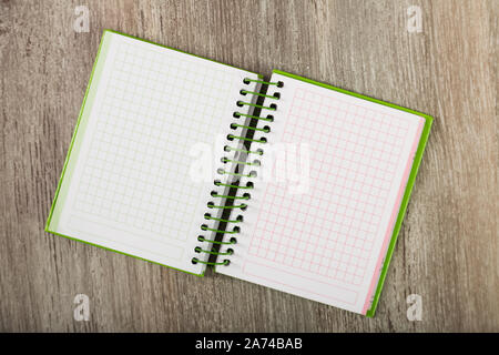 Open notebook lying on wooden surface Stock Photo