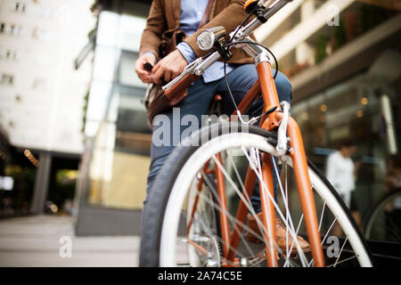 Happy businessman riding bicycle to work in morning Stock Photo