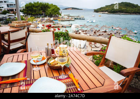 Restaurant with served table in seafront of Ionian sea on Ksamil Stock Photo