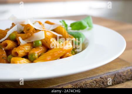 Food photography of a pasta dish with whisky sauce, green peas and parmesan shavings Stock Photo