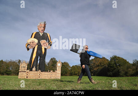 Artist Andrea Deans walks past the repaired effigy of Speaker John Bercow, holding the heads of Prime Minister Boris Johnson and Labour party leader Jeremy Corbyn, by the Edenbridge Bonfire Society at Breezehurst Farm Industrial Park, which will be burned at an annual bonfire celebration in Edenbridge, Kent. Stock Photo