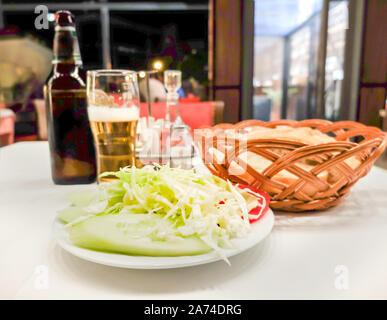 At at a restaurant in Montenegro's capital city.with salad dressing,olive oil,salt,pepper,and local beer. Stock Photo