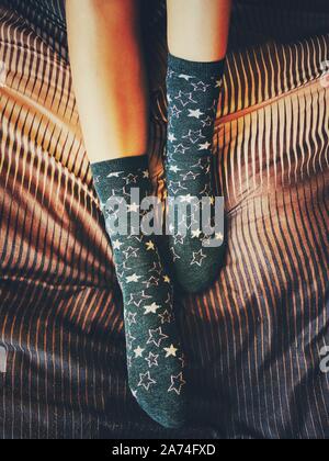 Legs of young beautiful girl in winter socks on the bed. Winter, cozy, clothes and lifestyle concept.