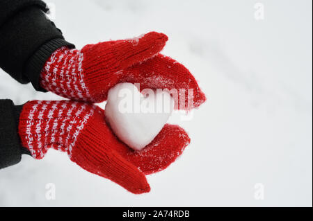 Female hands in mittens with heart on snow background Stock Photo Alamy